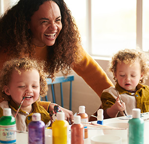 A mum and two kids in the decorating studio, surrounded by paints, at World of Wedgwood